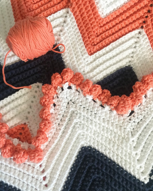 close up blue and orange crochet chevron blanket with puff border