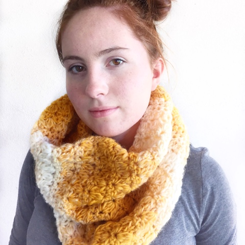 red haired girl wearing gold and white chunky crochet scarf