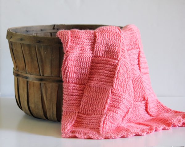 Pink Crochet Basketweave Blanket draped over wooden basket