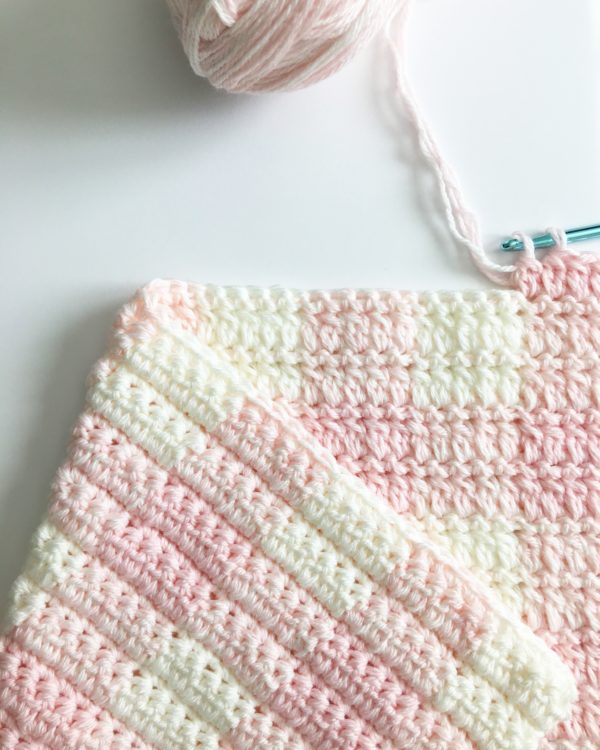 Crochet Light Pink Gingham Blanket laying flat with yarn