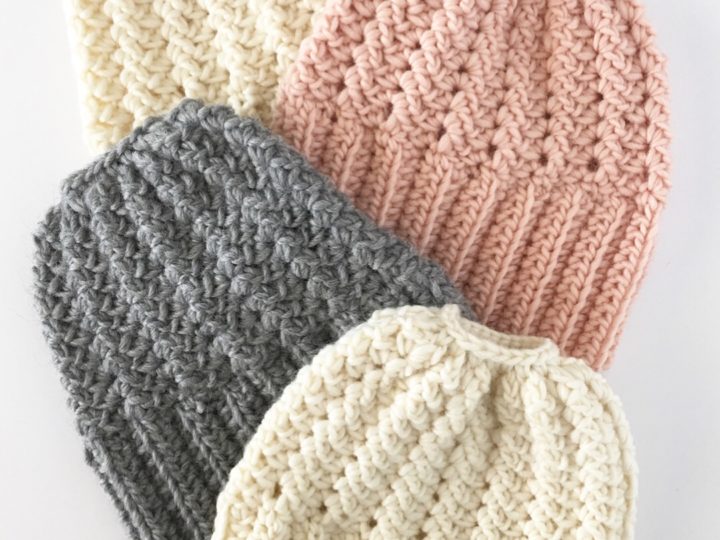 4 crochet bun beanies laying flat on white background