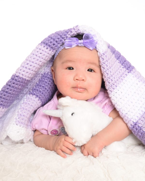 baby with purple gingham blanket