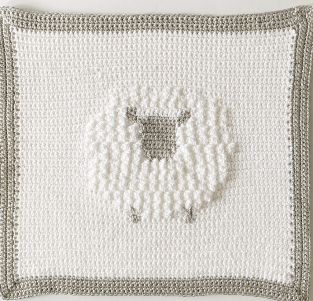 crochet blanket with sheep in middle