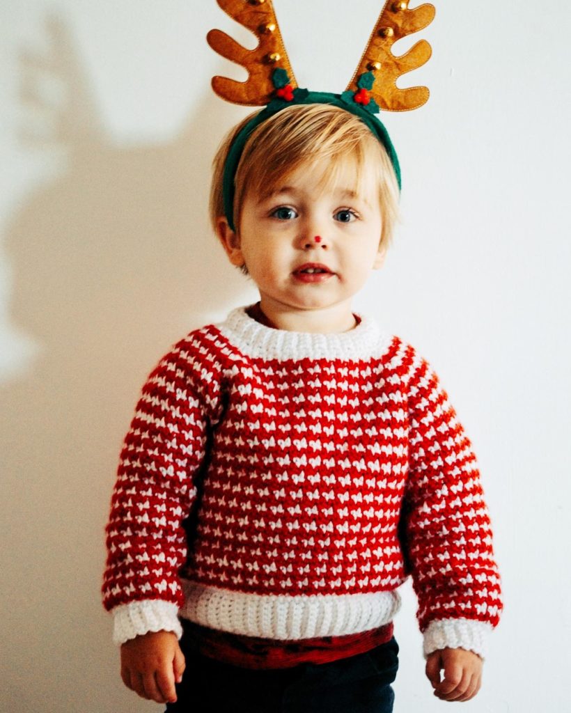 little boy wearing red crochet sweater