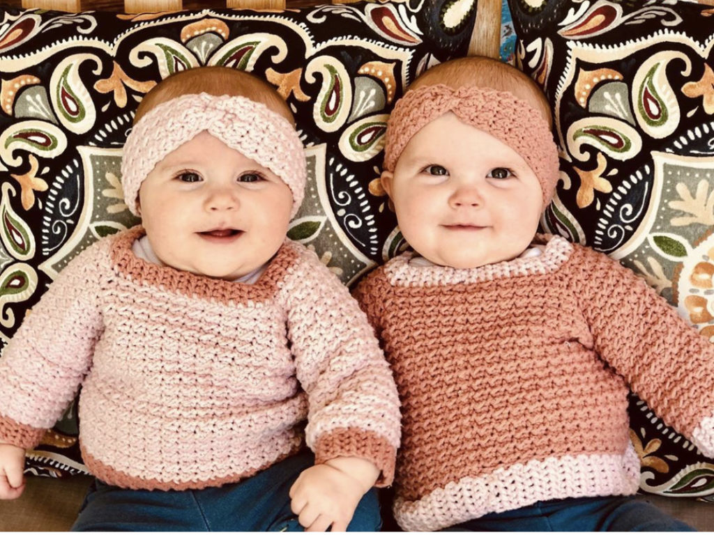twin girl babies wearing crochet sweaters and headbands