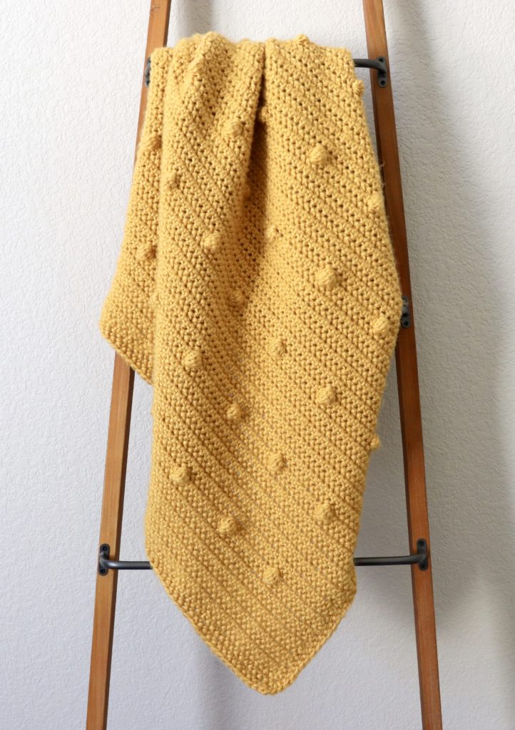 gold polka dots blanket on ladder