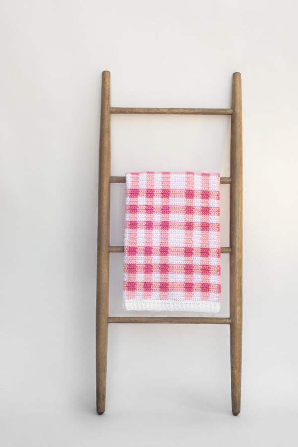 pink gingham blanket on ladder