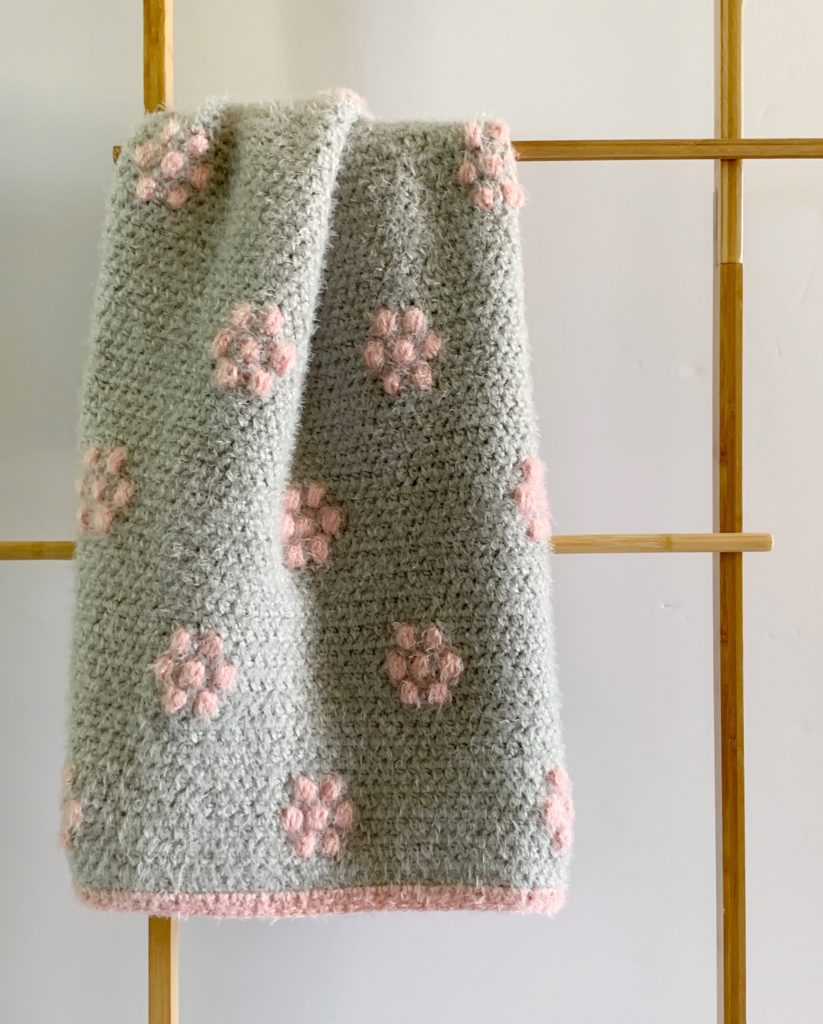 gray blanket with pink flowers on ladder