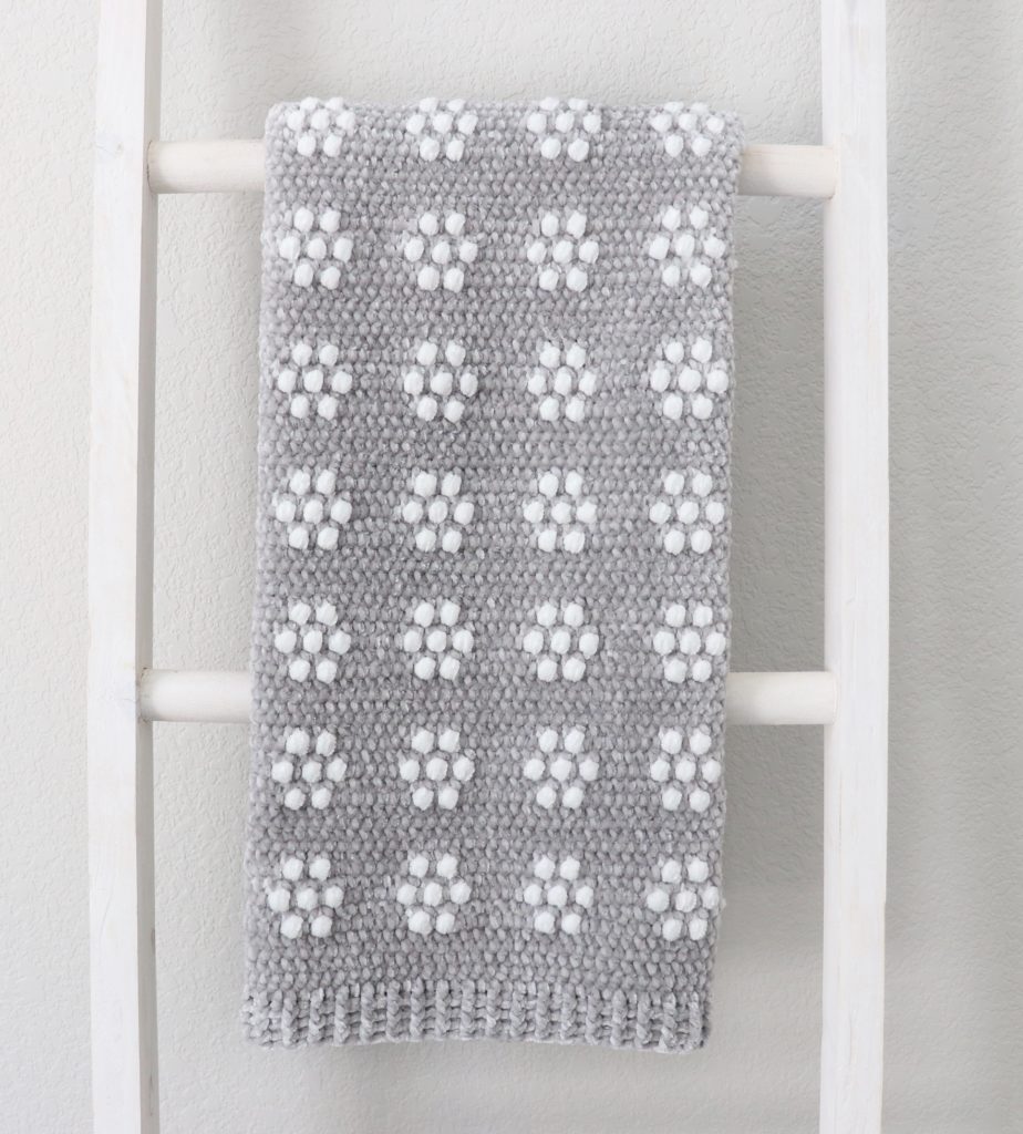 gray and white flowers blanket on ladder
