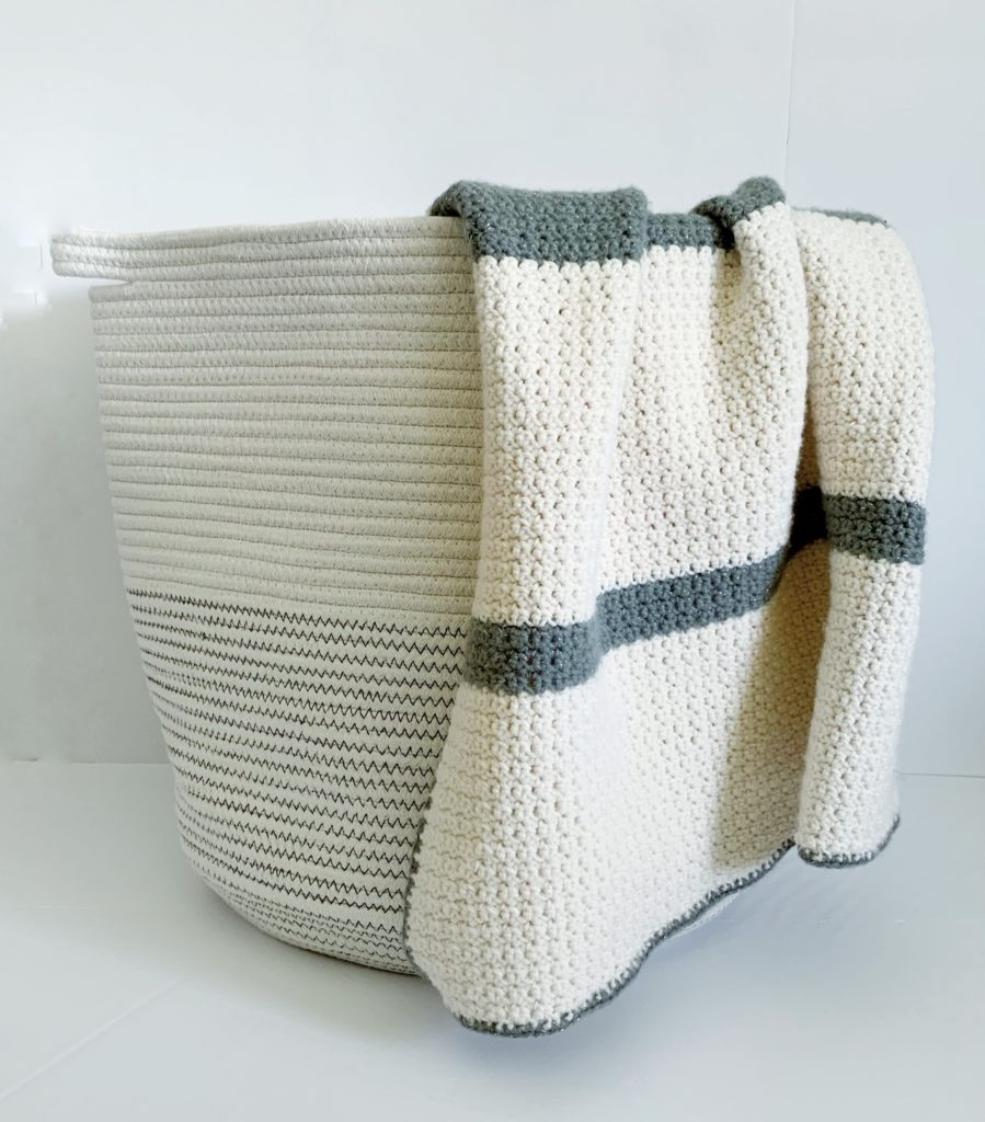 beginner grit stitch blanket draped over basket