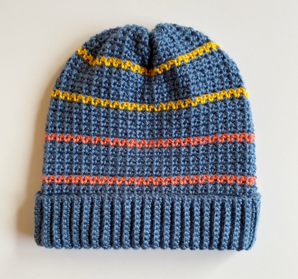 blue crochet mesh stitch hat with gold and orange stripes