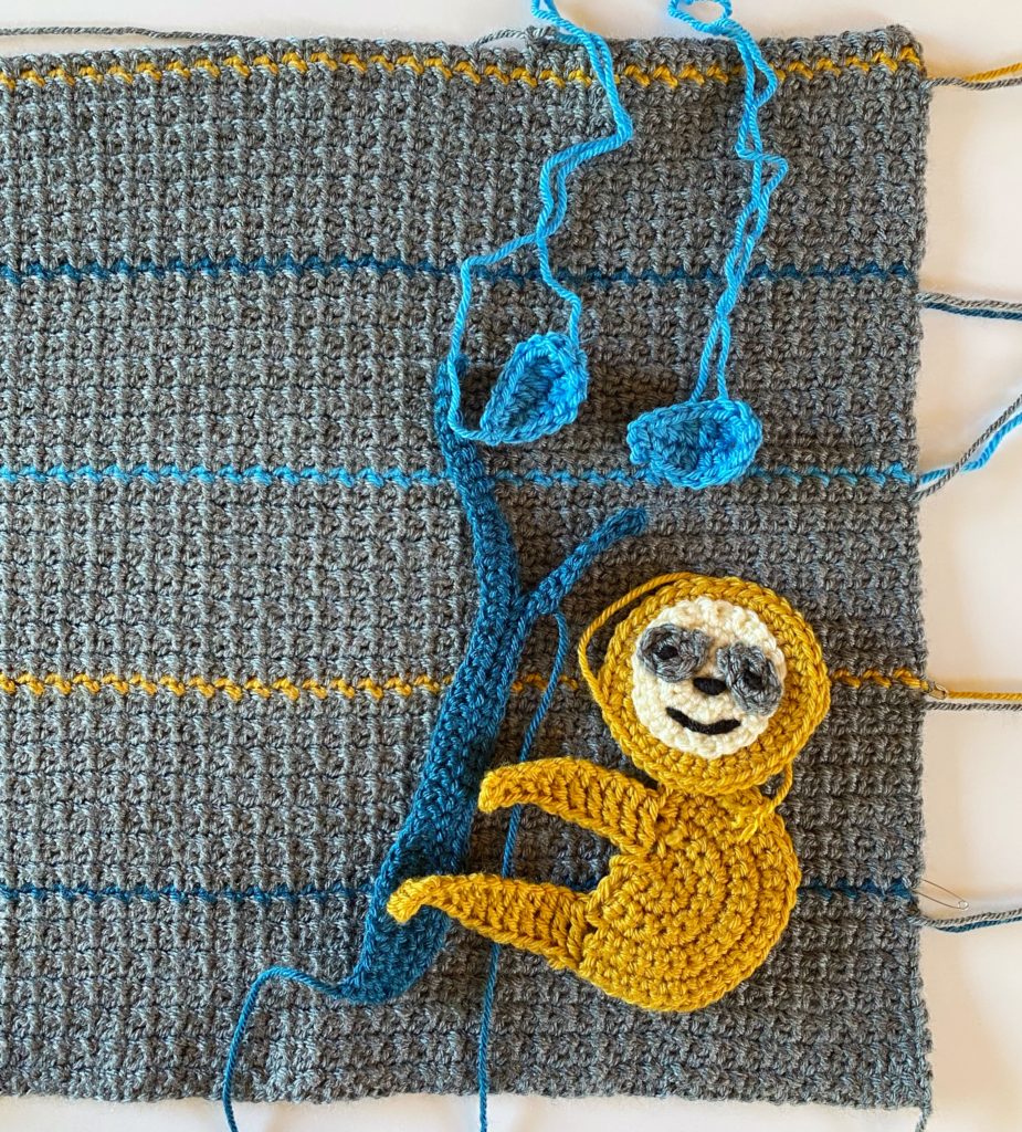 sloth on crochet blanket