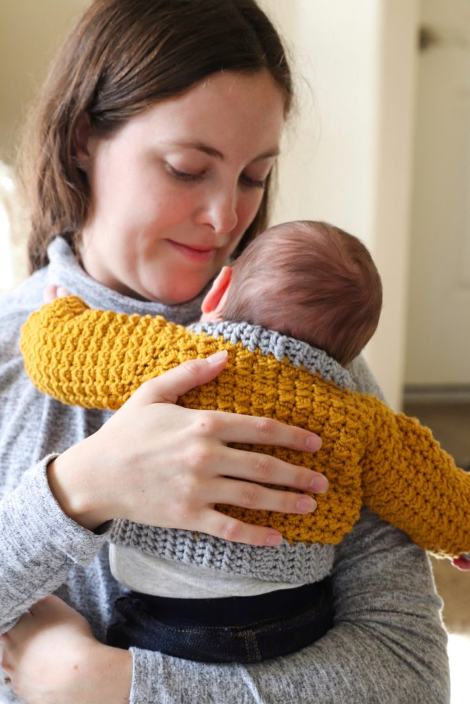 mom holding baby in crochet sweater