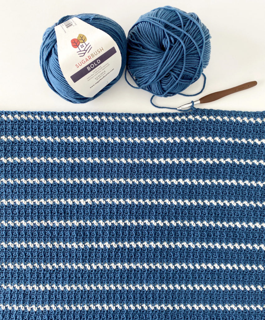 blue crochet blanket with thin white stripes
