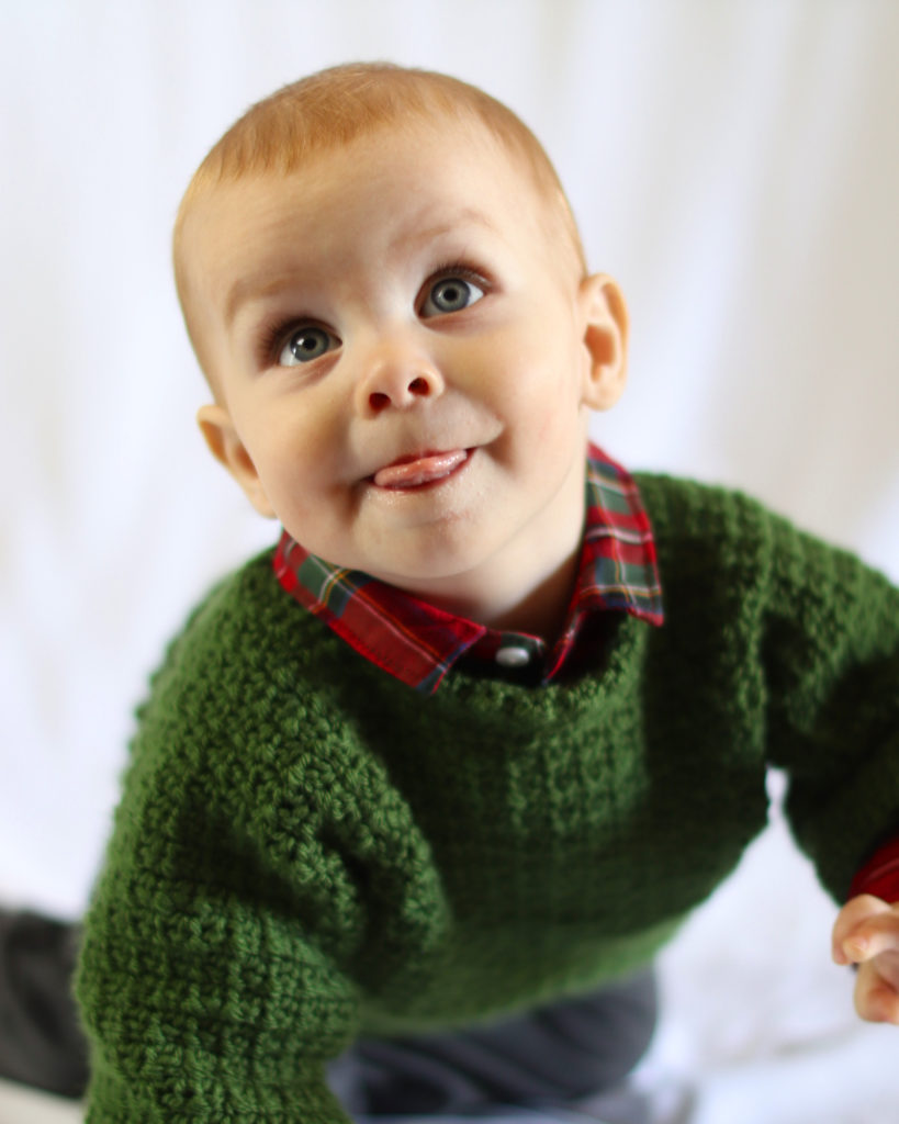 baby wearing green crochet sweater