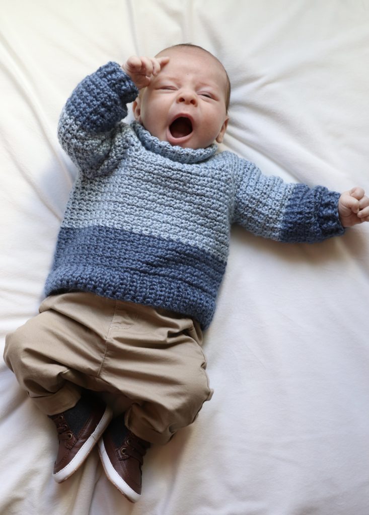 baby wearing blue crochet sweater