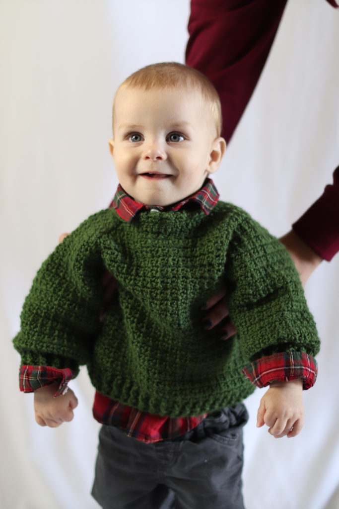 baby in green crochet sweater
