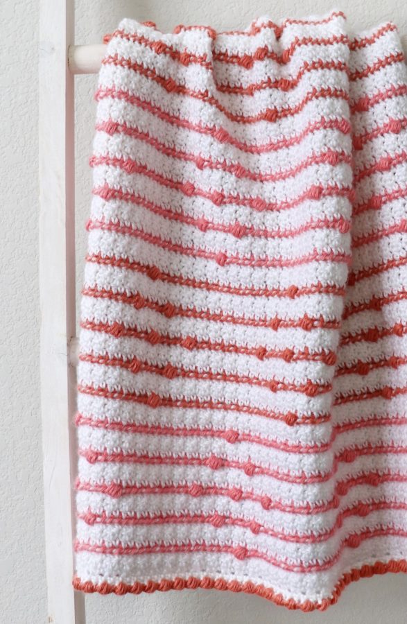 crochet blanket with stripes and bobbles on ladder