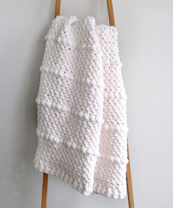 chunky white crochet throw on ladder