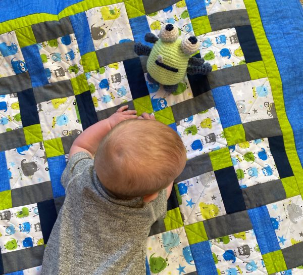 baby jack on quilt with crochet monster