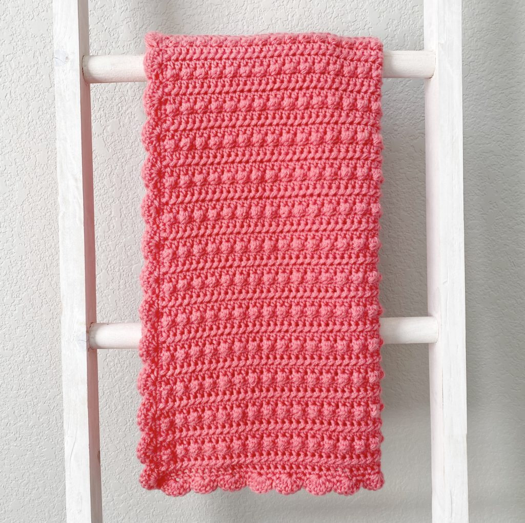 textured pink crochet blanket with shell border on ladder