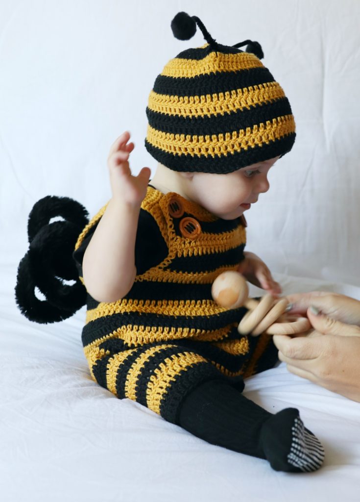 baby boy wearing black and gold striped crochet romper and hat