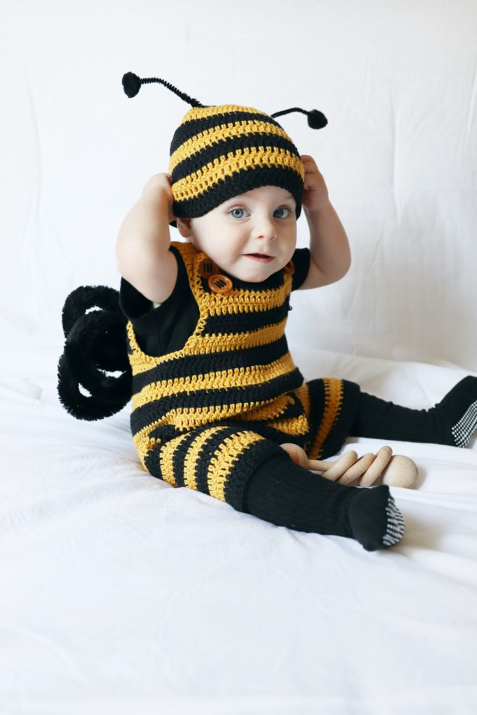 baby boy sitting and wearing black and gold striped crochet romper