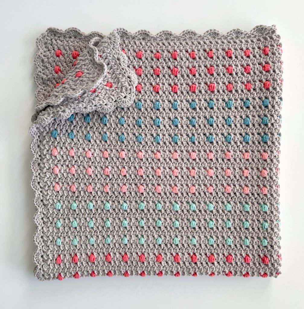 crochet blanket with colorful polka dots and shell border