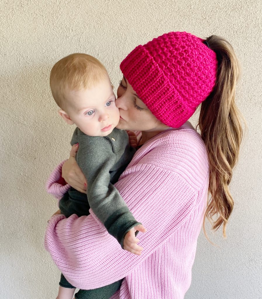 mom kissing baby wearing a crochet hat