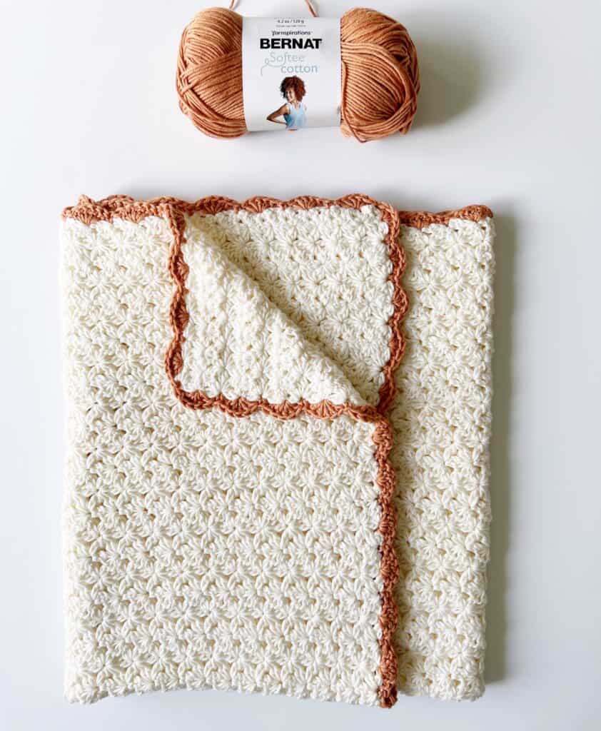 crochet cream flower blanket with orange shell border