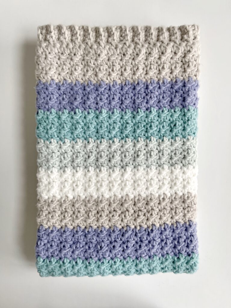 crochet blanket with gray and blue stripes folded
