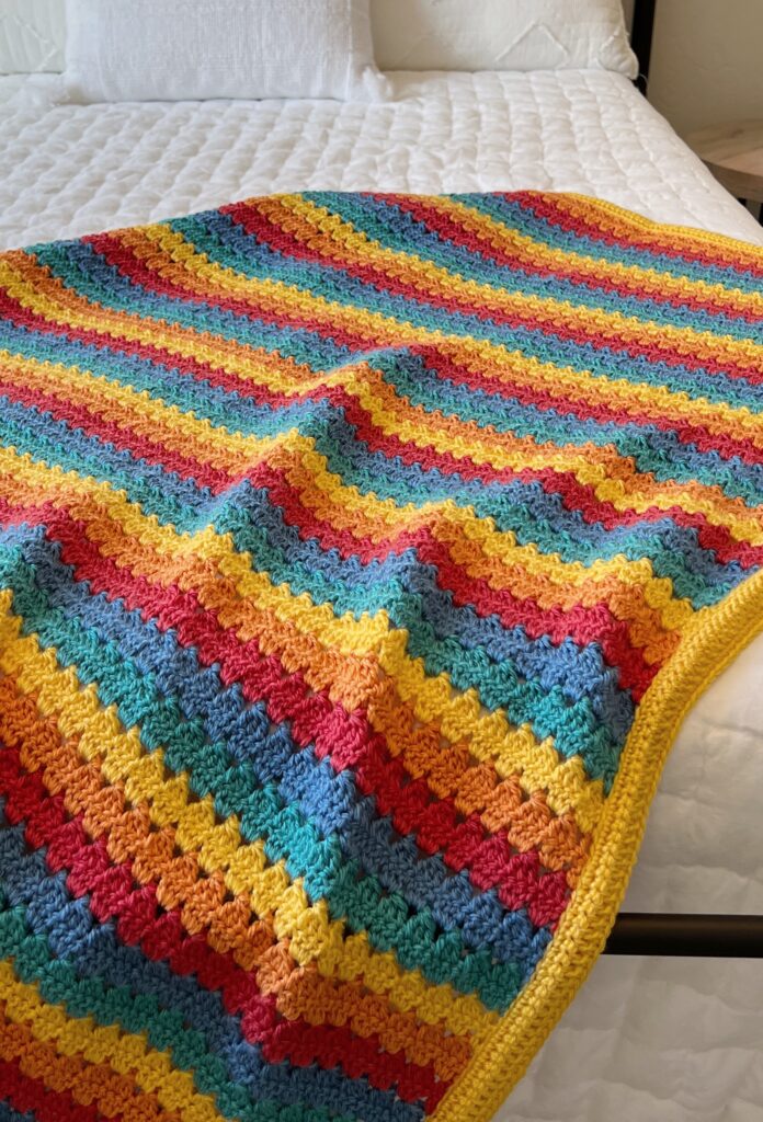 rainbow modern granny blanket laying on bed