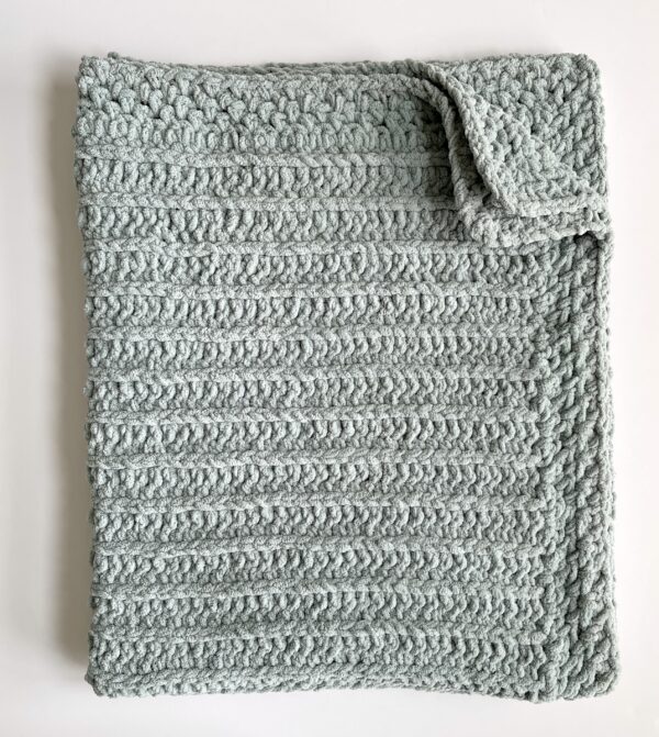 green crochet blanket folded