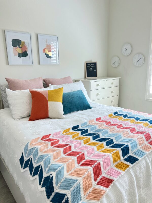 colorful crocheted blanket on a bed