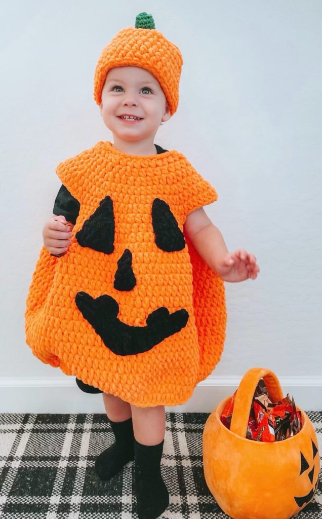 little boy wearing halloween pumpkin and hat