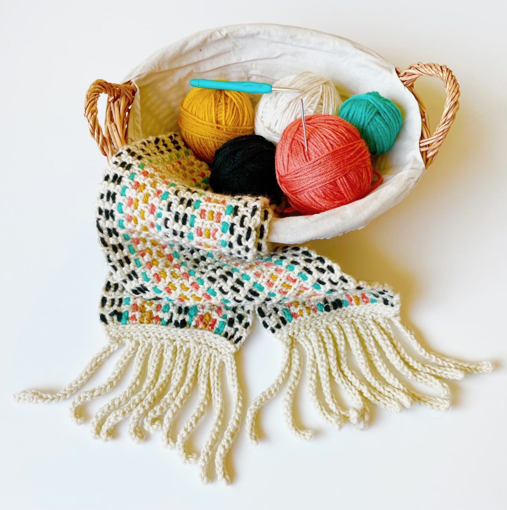 scarf and balls of yarn in basket