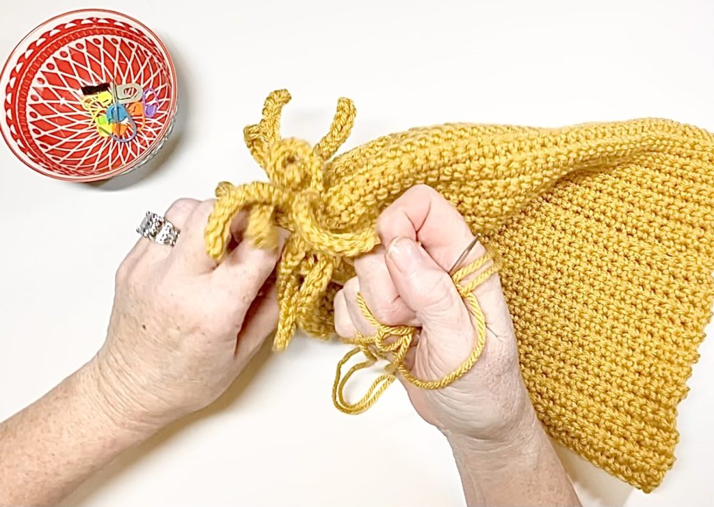 woman tying crochet hat