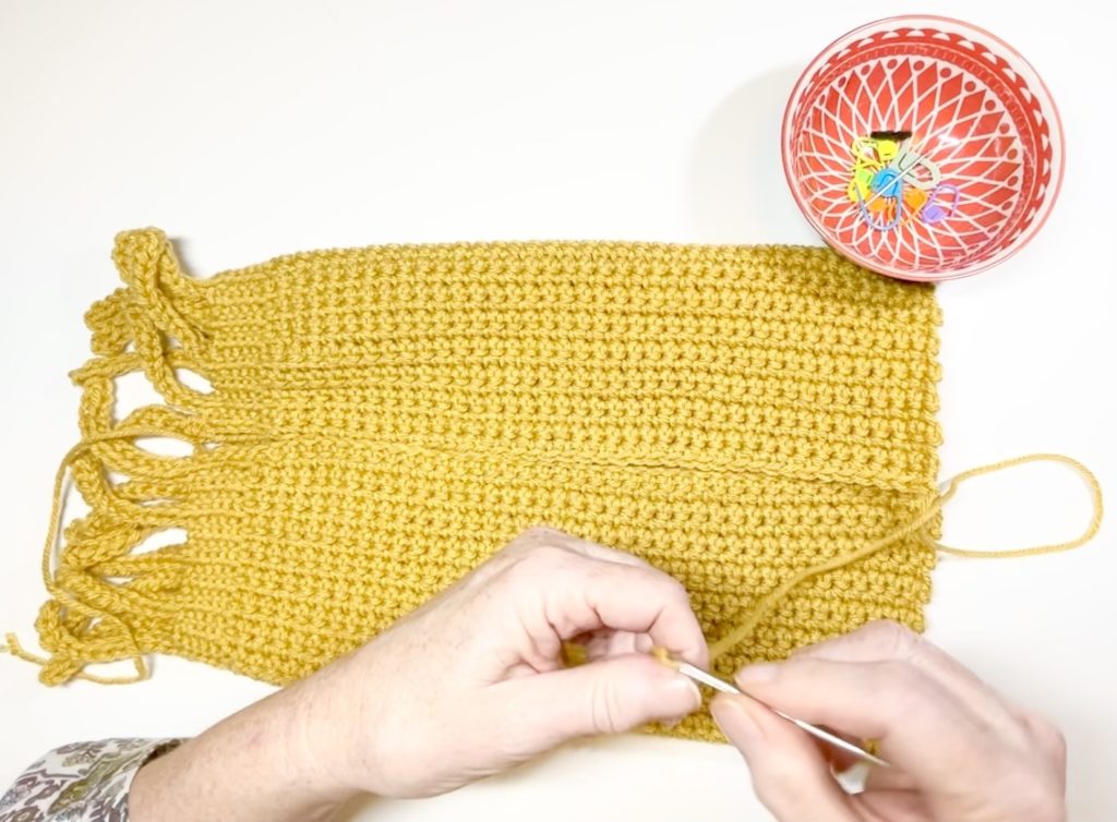 woman stitching crochet hat