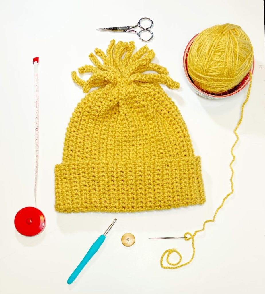 beanie on table with crochet tools