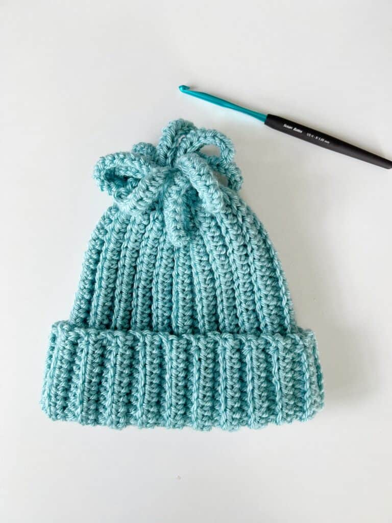 Blue crochet hat with crochet hook