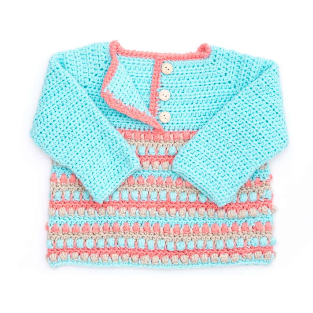 multi colored crochet baby sweater. The colors range from teal to shades of peach and orange.