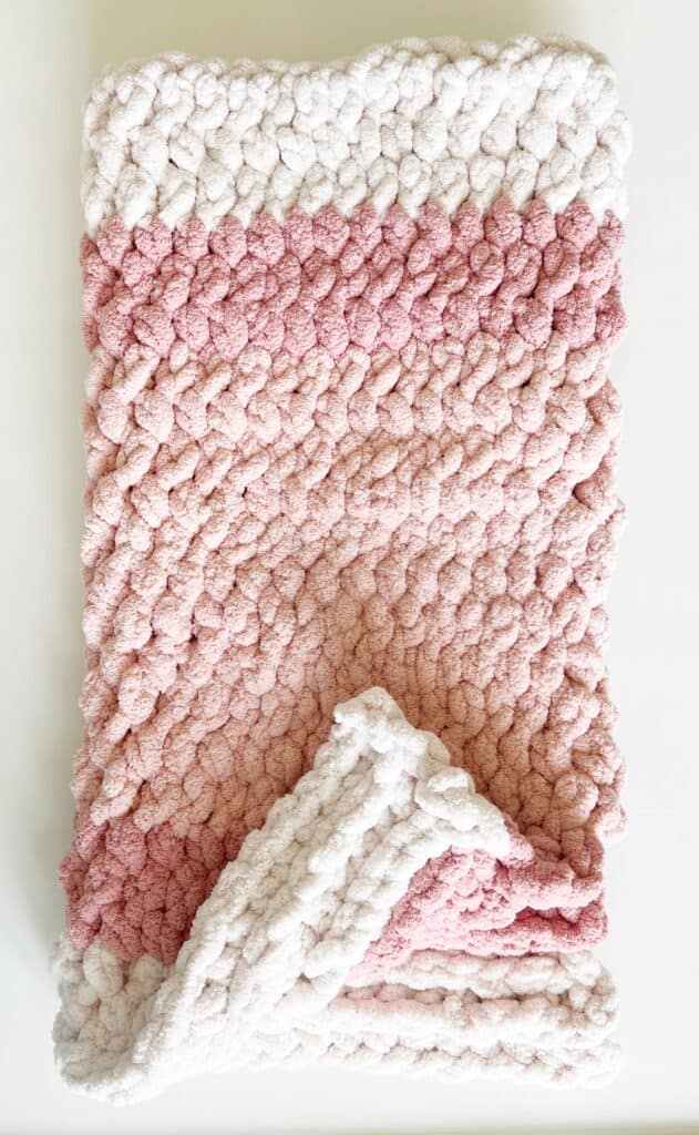 pink and white crochet blanket flat lay