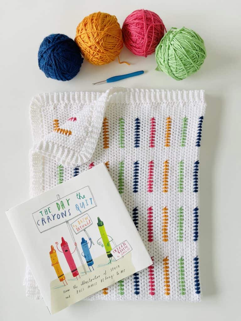 yarn skeins, crochet hook, and children's book