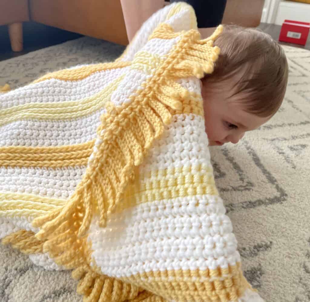 baby underneath crochet blanket