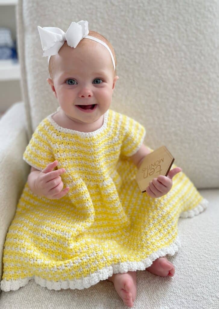 baby girls wearing yellow crochet dress and white hair bow