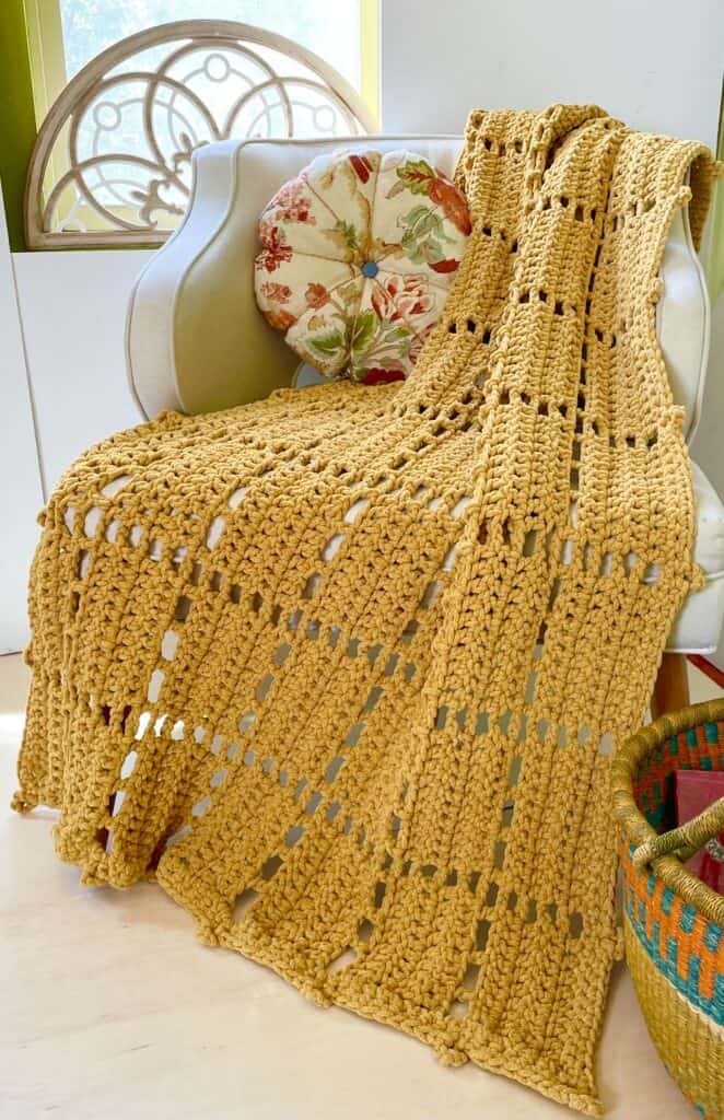 yellow crochet blanket over chair