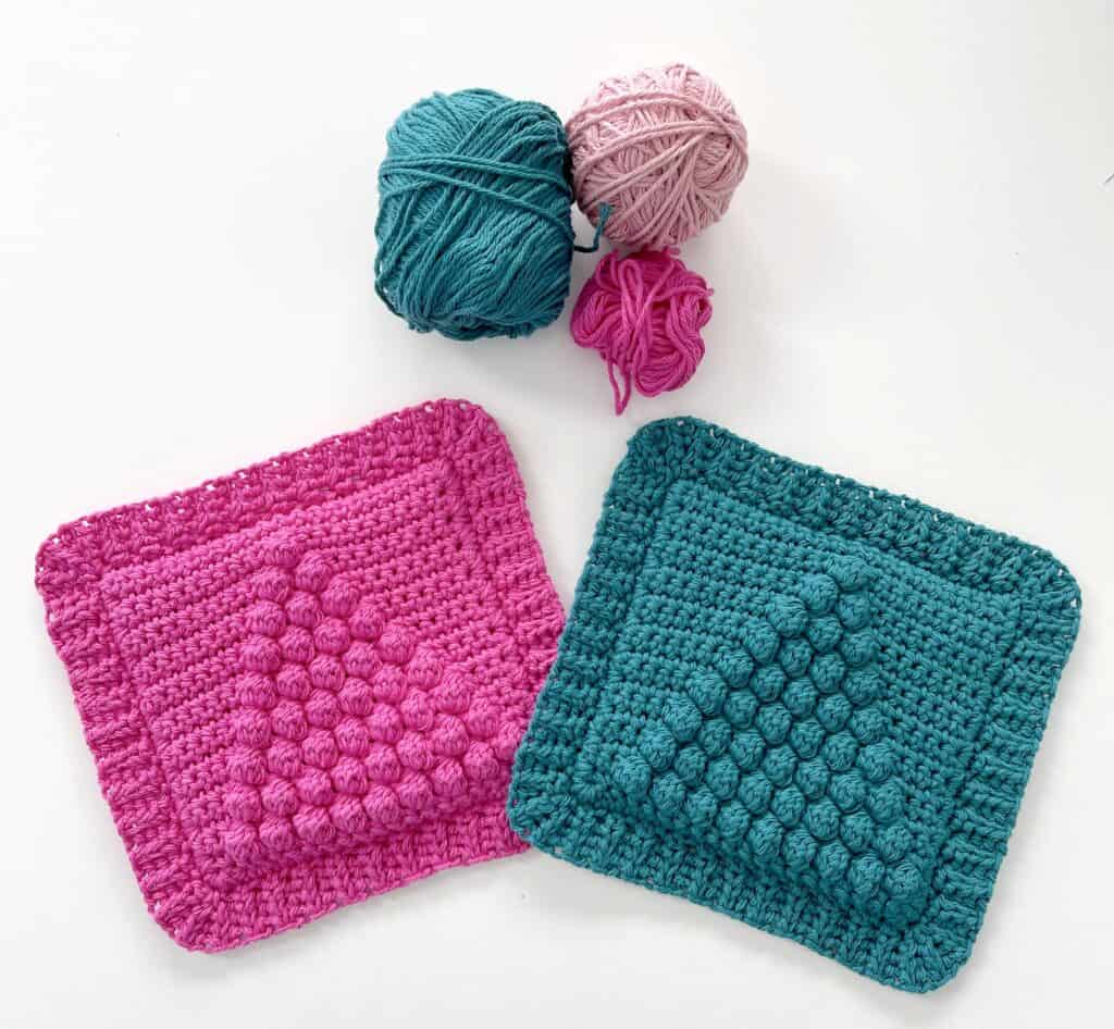 two crochet hot pads with three yarn balls