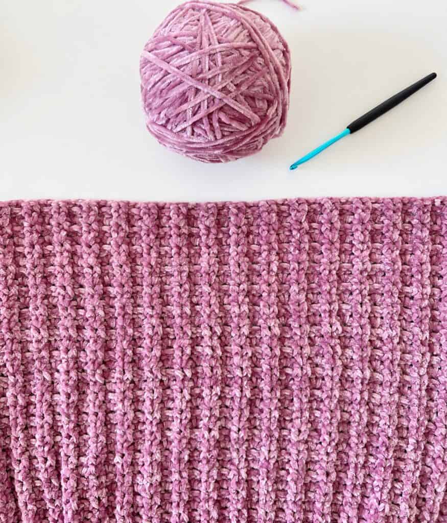 close of crochet blanket, yarn ball, crochet hook
