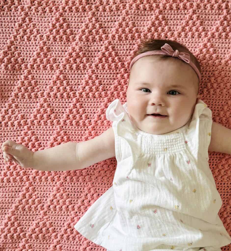 baby Nora on pink crochet blanket