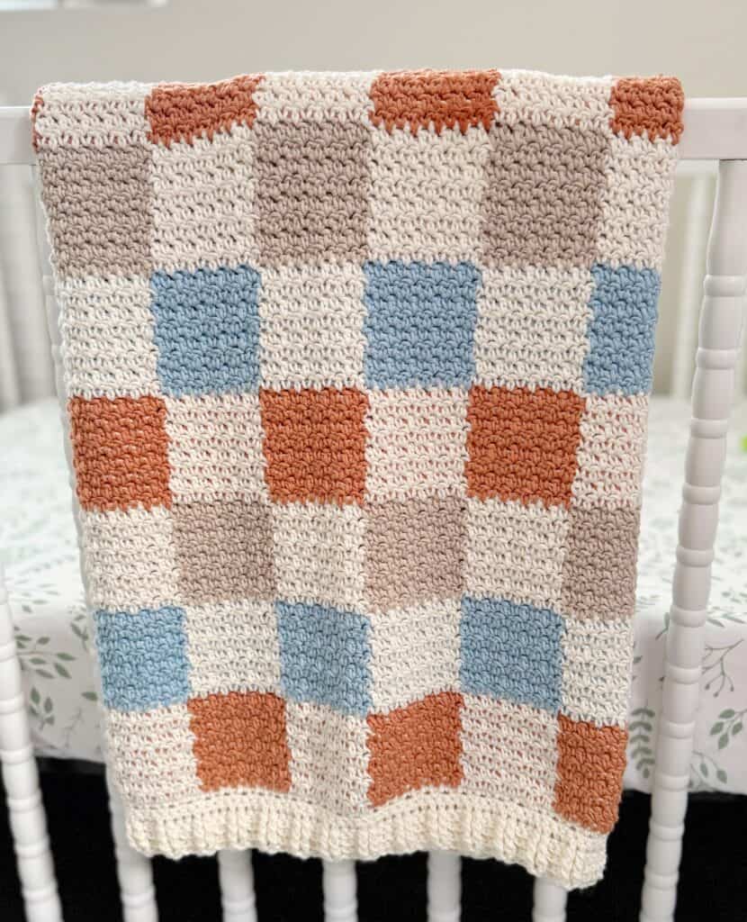 crochet blanket draped over baby crib